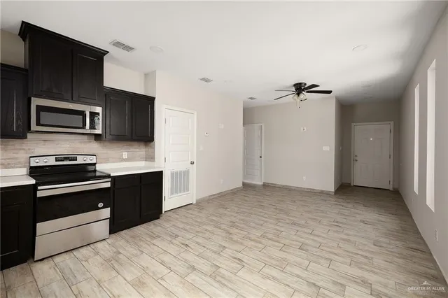 a kitchen with granite countertop a stove and a microwave