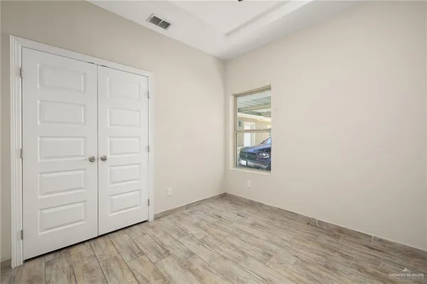 an empty room with a hardwood and hallway