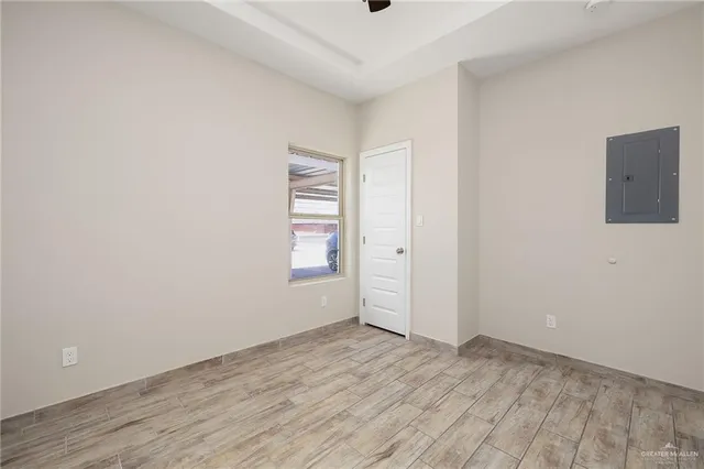 an empty room with wooden floor and windows