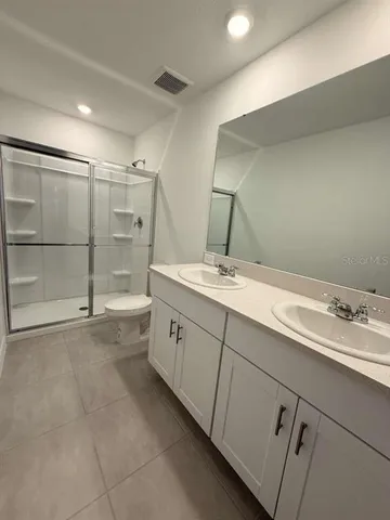 a bathroom with a double vanity sink and a mirror