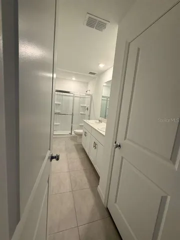 a bathroom with a glass door shower a sink and a toilet