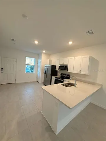a large kitchen with a large counter top appliances and cabinets