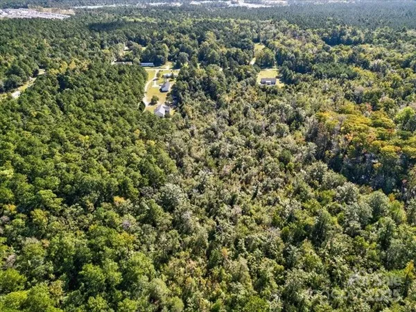 an aerial view of a houses with a lush green hillside