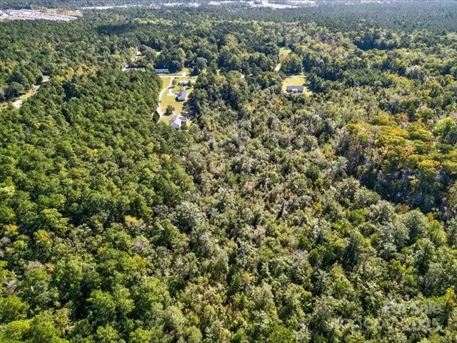 an aerial view of a houses with a lush green hillside