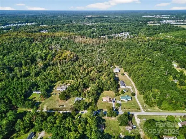 an aerial view of residential houses with outdoor space and trees