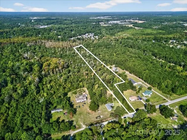 an aerial view of residential houses with outdoor space and trees