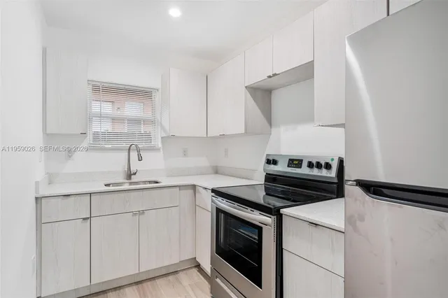 a kitchen with cabinets stainless steel appliances and a sink