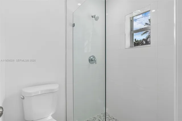 a bathroom with a toilet and a shower