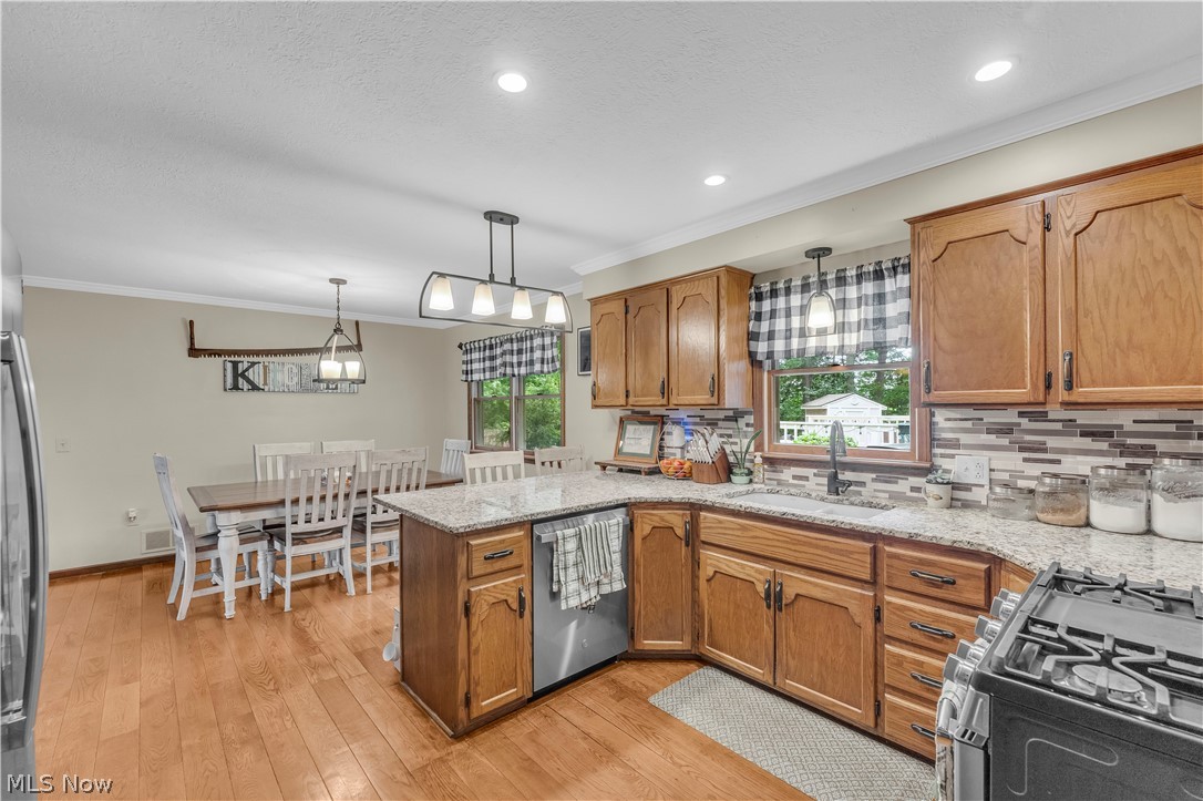 408 River Road Canal Fulton, OH 44614 - Photo 10 of 42 Open-concept kitchen and dining area featuring wood-finish flooring, recessed lighting, and a kitchen island with a granite-style countertop