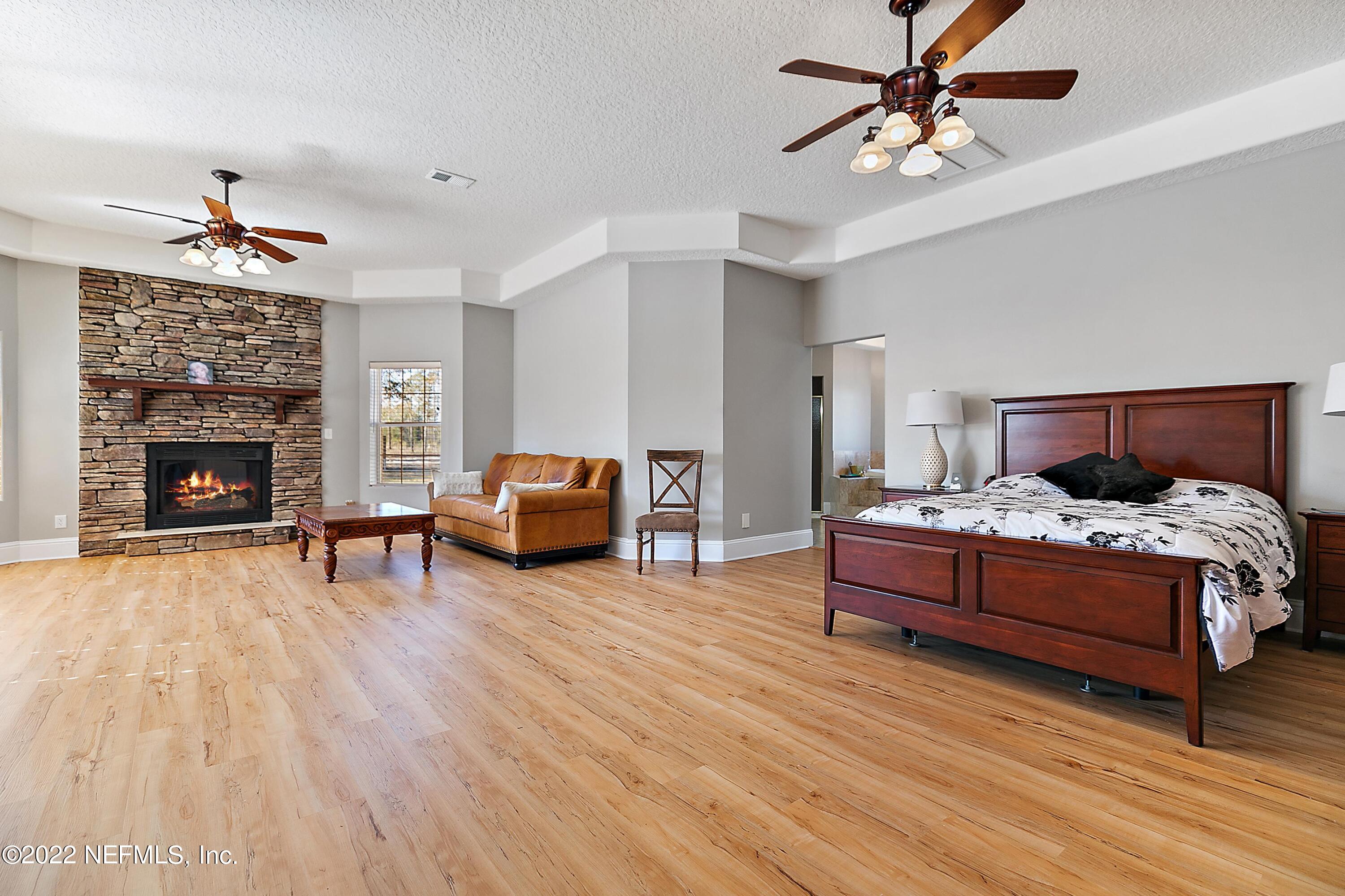 14394 Bob Burnsed Road Glen St. Mary, FL 32040 - Photo 15 of 36 a spacious bedroom with a bed and a fireplace