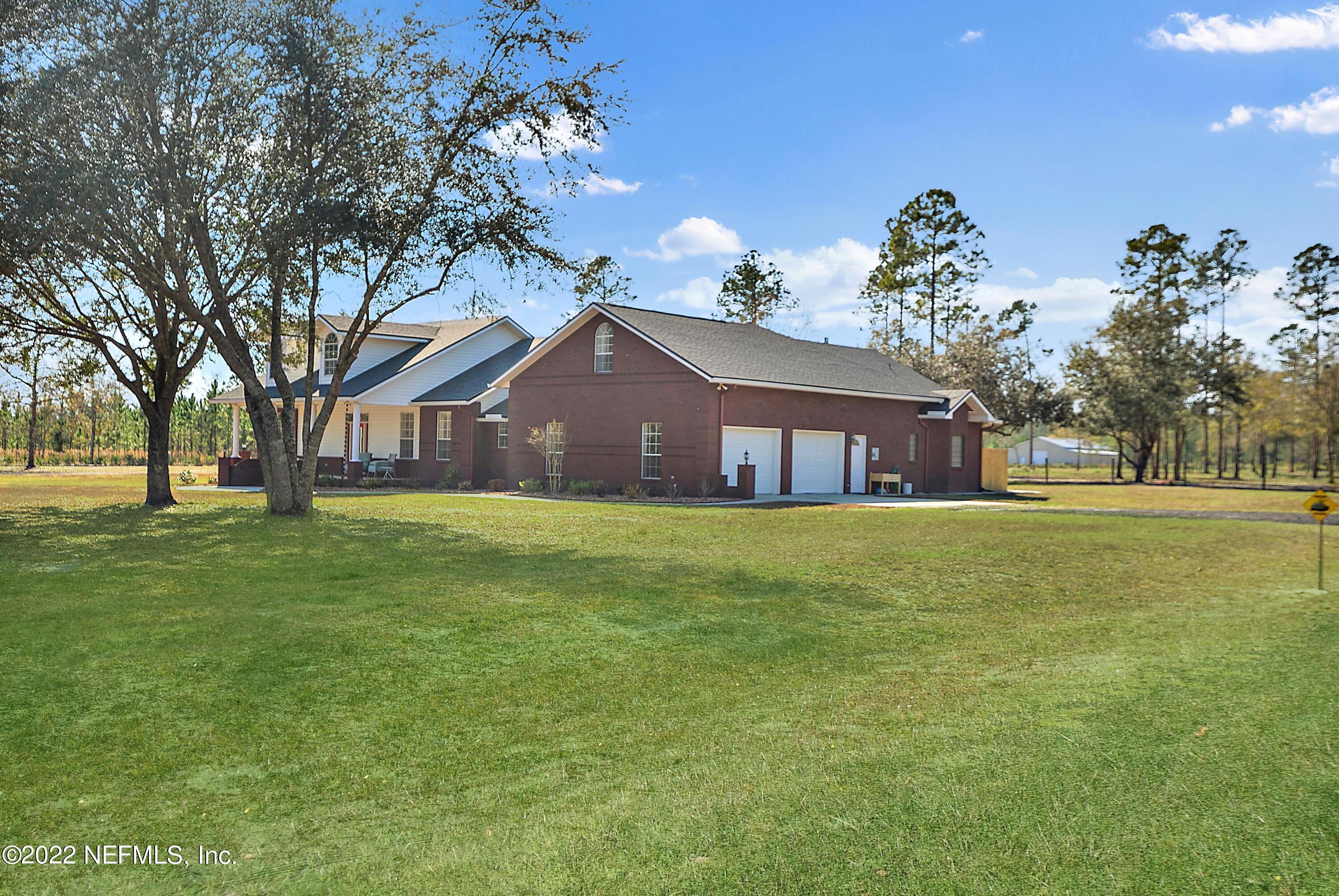 14394 Bob Burnsed Road Glen St. Mary, FL 32040 - Photo 2 of 36 a front view of a house with a garden