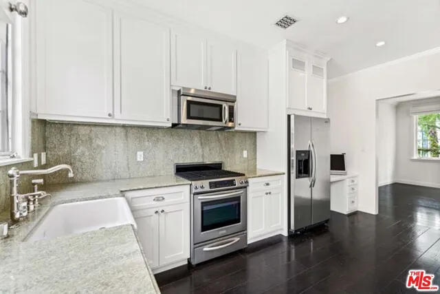 a kitchen with stainless steel appliances granite countertop a stove a sink and a microwave