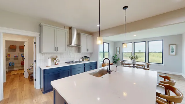 a large kitchen with stainless steel appliances a large center island attached withe living room