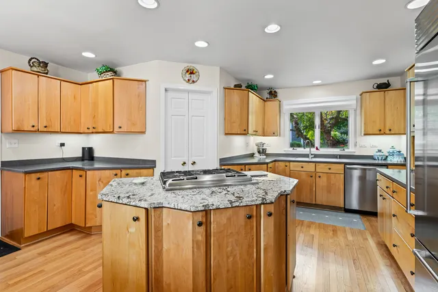 a kitchen with stainless steel appliances granite countertop wooden cabinets a sink and a stove
