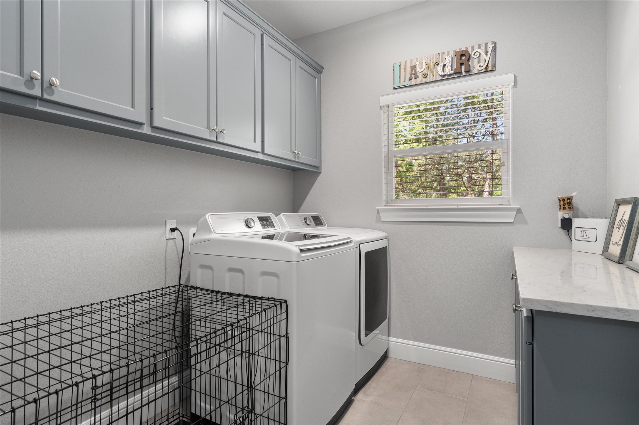136 Fawn Hollow Elgin, TX 78621 - Photo 29 of 40 Dedicated laundry space featuring extensive upper cabinetry, a window with blinds, and a built-in counter with lower cabinetry