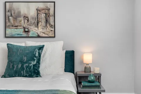 a bedroom with a bed and painting on the wall