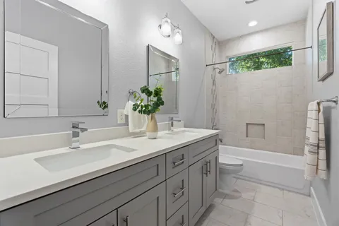 a bathroom with a granite countertop sink a mirror and a bathtub