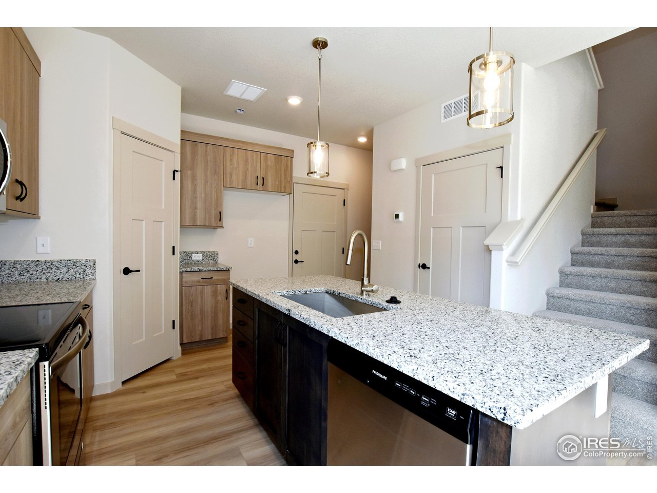 268 East 4th Street Berthoud, CO 80513 - Photo 14 of 39 a kitchen with kitchen island granite countertop a sink stove and refrigerator