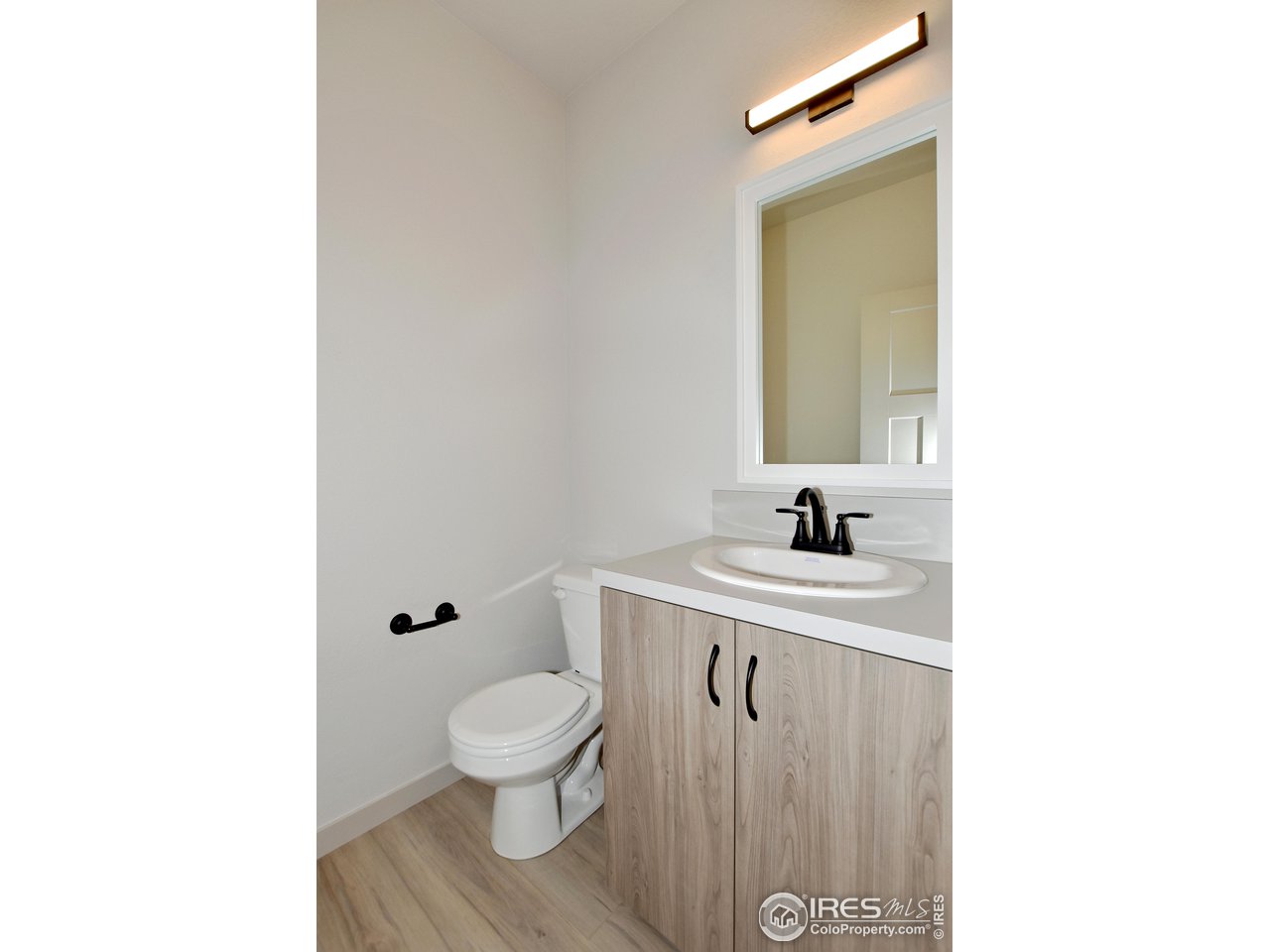 268 East 4th Street Berthoud, CO 80513 - Photo 19 of 39 a bathroom with a toilet a sink and mirror