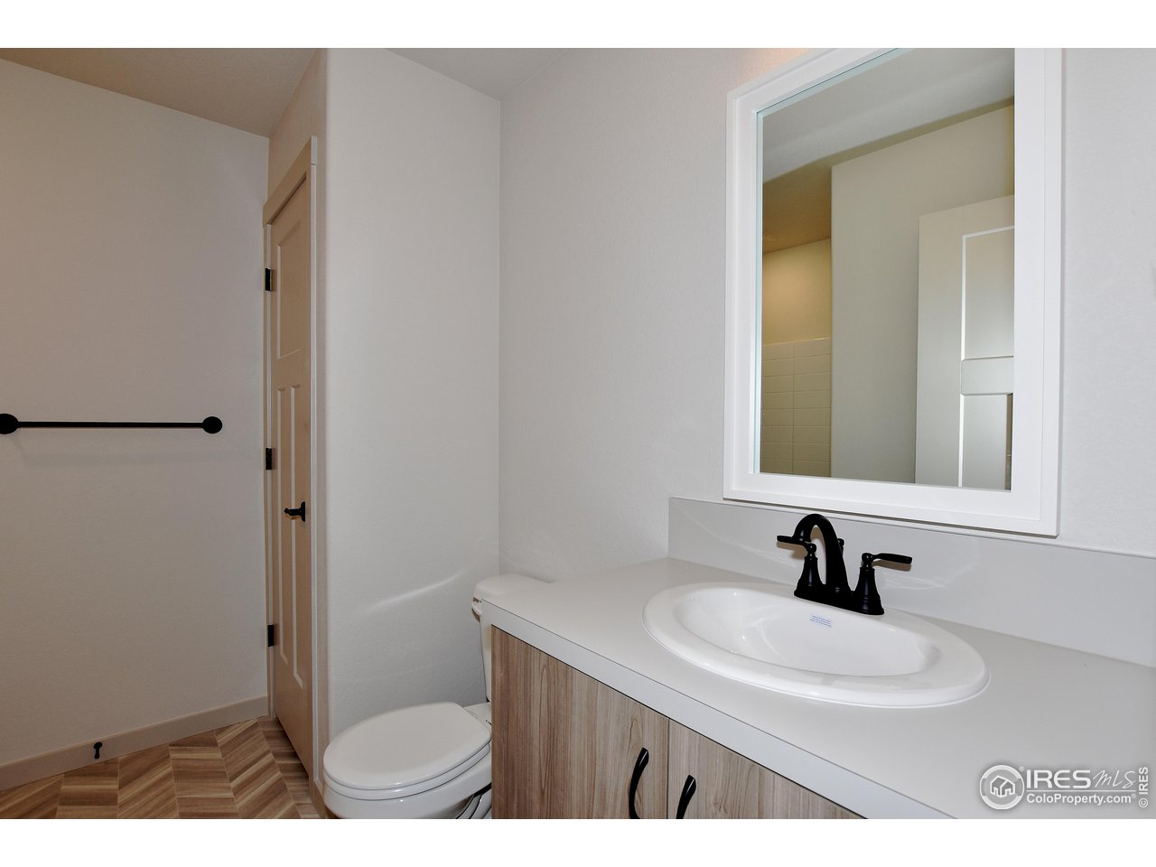 268 East 4th Street Berthoud, CO 80513 - Photo 35 of 39 a bathroom with a sink a toilet and a mirror