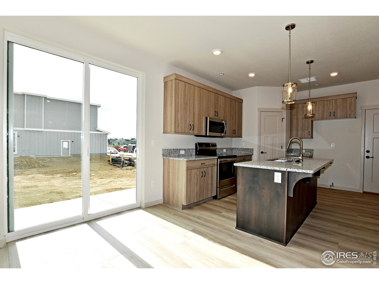 268 East 4th Street Berthoud, CO 80513 - Photo 10 of 39 a kitchen with kitchen island a sink a counter top space stainless steel appliances and cabinets