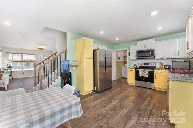 a open kitchen with stainless steel appliances kitchen island granite countertop a refrigerator and a stove top oven