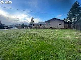 a backyard of a house with lots of green space and wooden fence