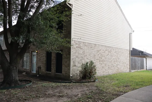 a view of a house with a yard and tree