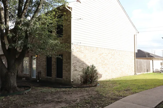a view of a house with backyard and a tree