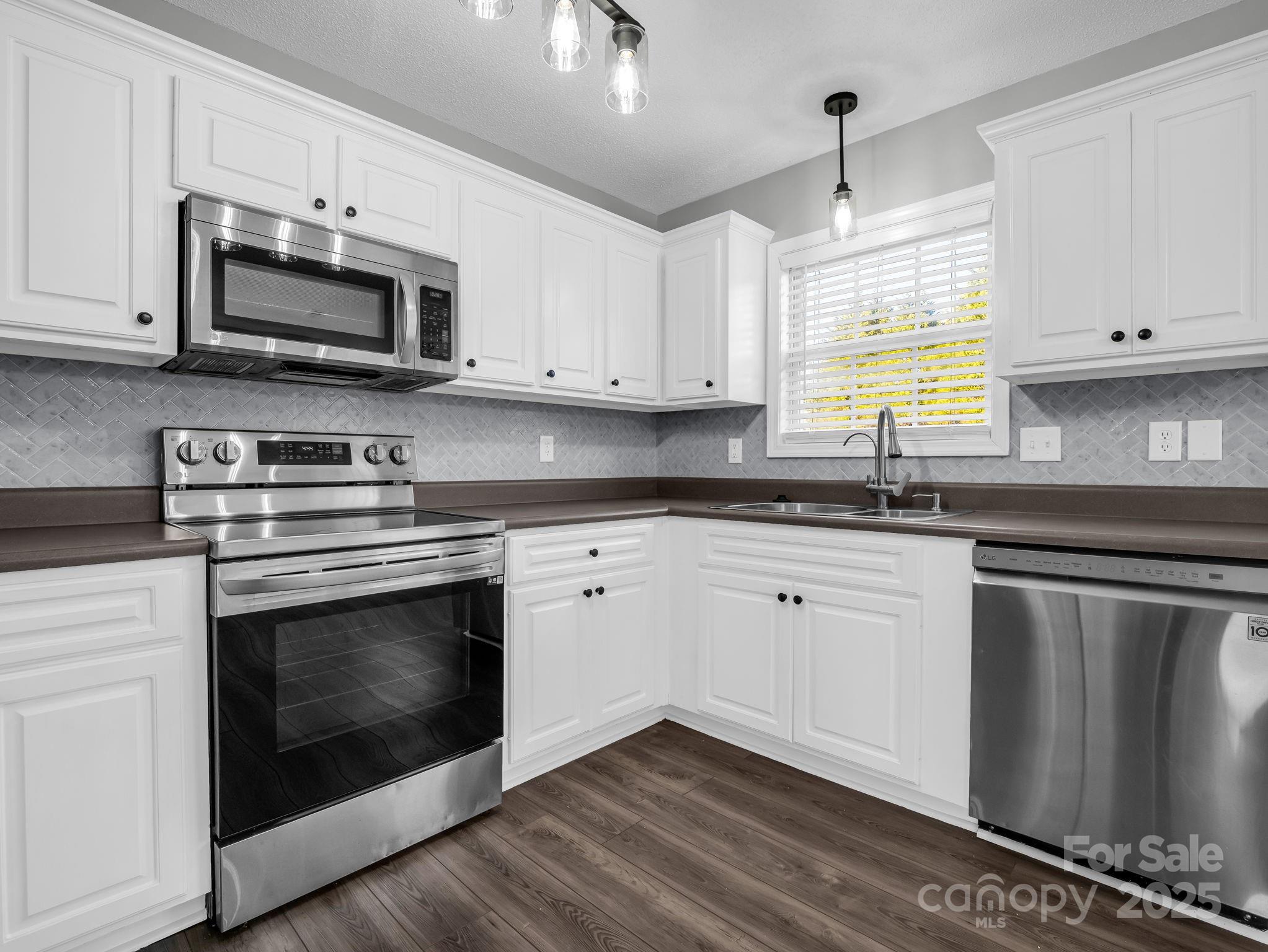 340 Sarratt Creek Road Gaffney, SC 29341 - Photo 12 of 46 a kitchen with granite countertop white cabinets stainless steel appliances and a sink