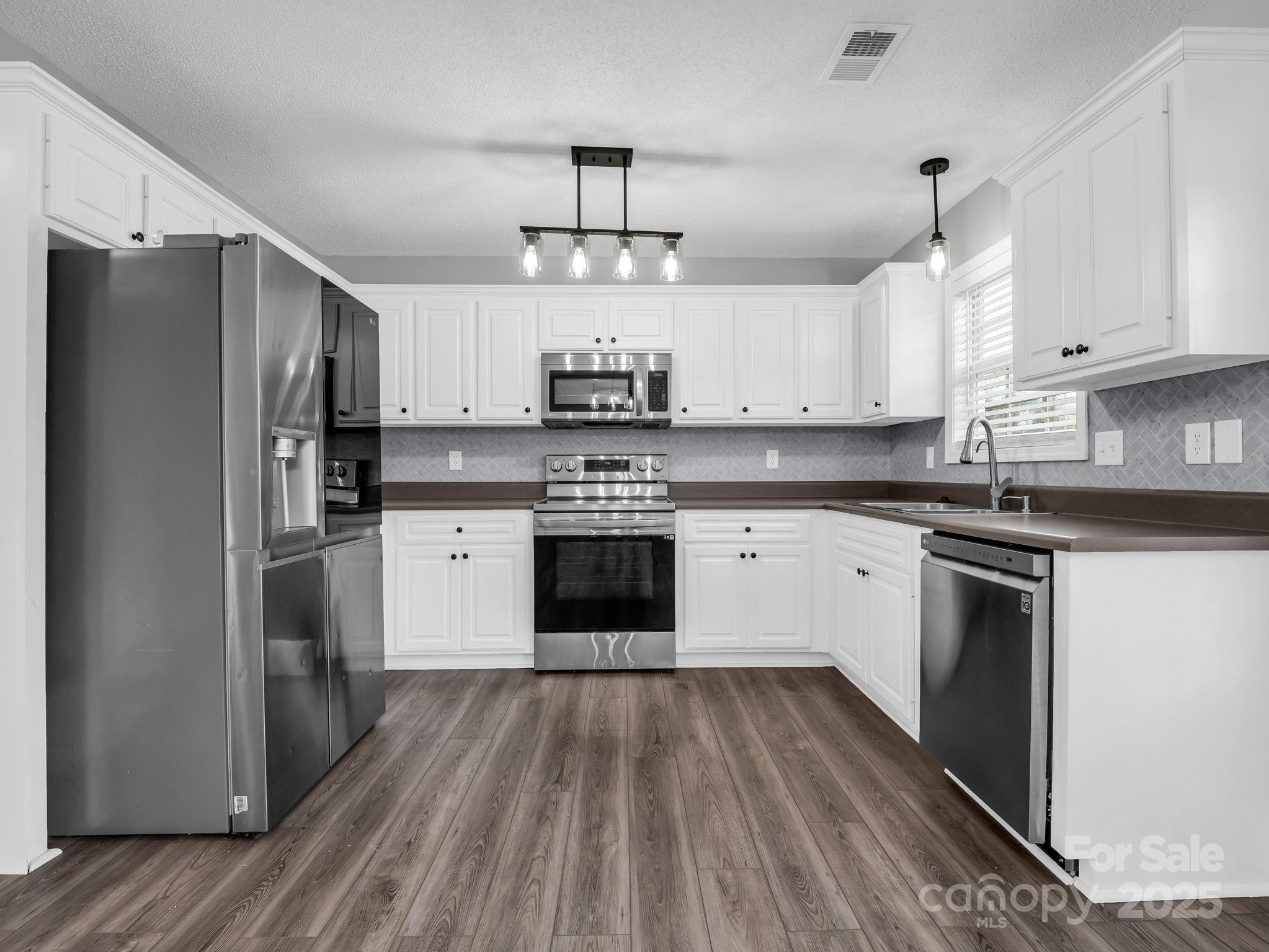340 Sarratt Creek Road Gaffney, SC 29341 - Photo 13 of 46 a kitchen with stainless steel appliances granite countertop a stove a refrigerator and a sink with cabinets