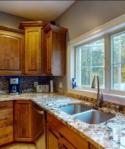 a kitchen with sink a window and cabinets