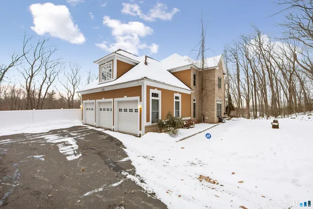 a view of a white house with a yard covered in snow