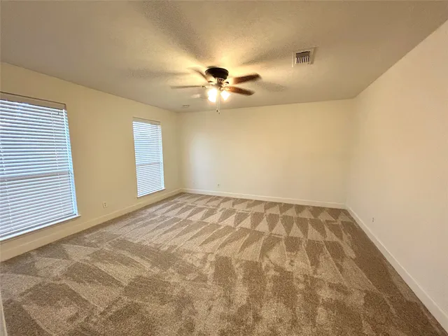 a view of a big room with carpet and windows