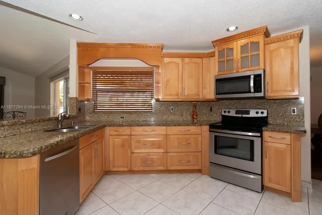 a kitchen with stainless steel appliances granite countertop a stove sink and microwave