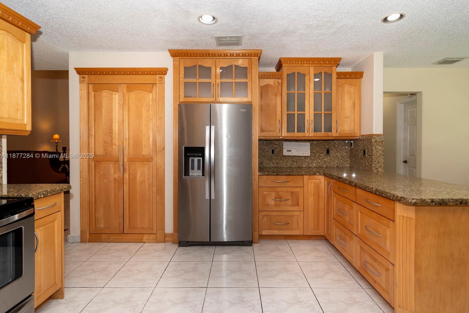 2293 Southwest 182nd Way Miramar, FL 33029 - Photo 12 of 41 a kitchen with stainless steel appliances granite countertop a refrigerator and a stove