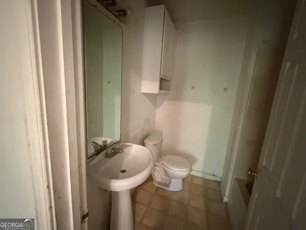 a bathroom with a sink toilet and a mirror