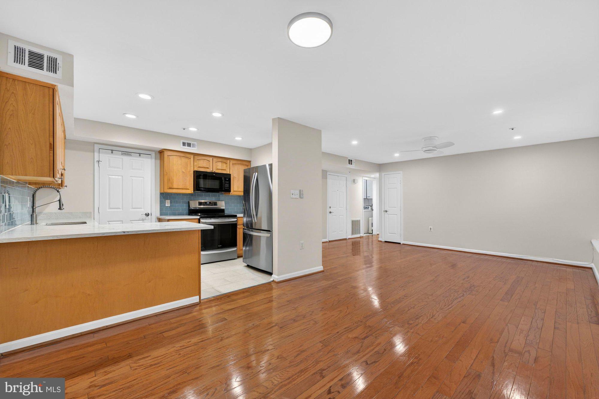 207 Park Street Vienna, VA 22180 - Photo 13 of 45 a view of kitchen with stainless steel appliances granite countertop a stove top oven a sink dishwasher and a microwave with wooden floor