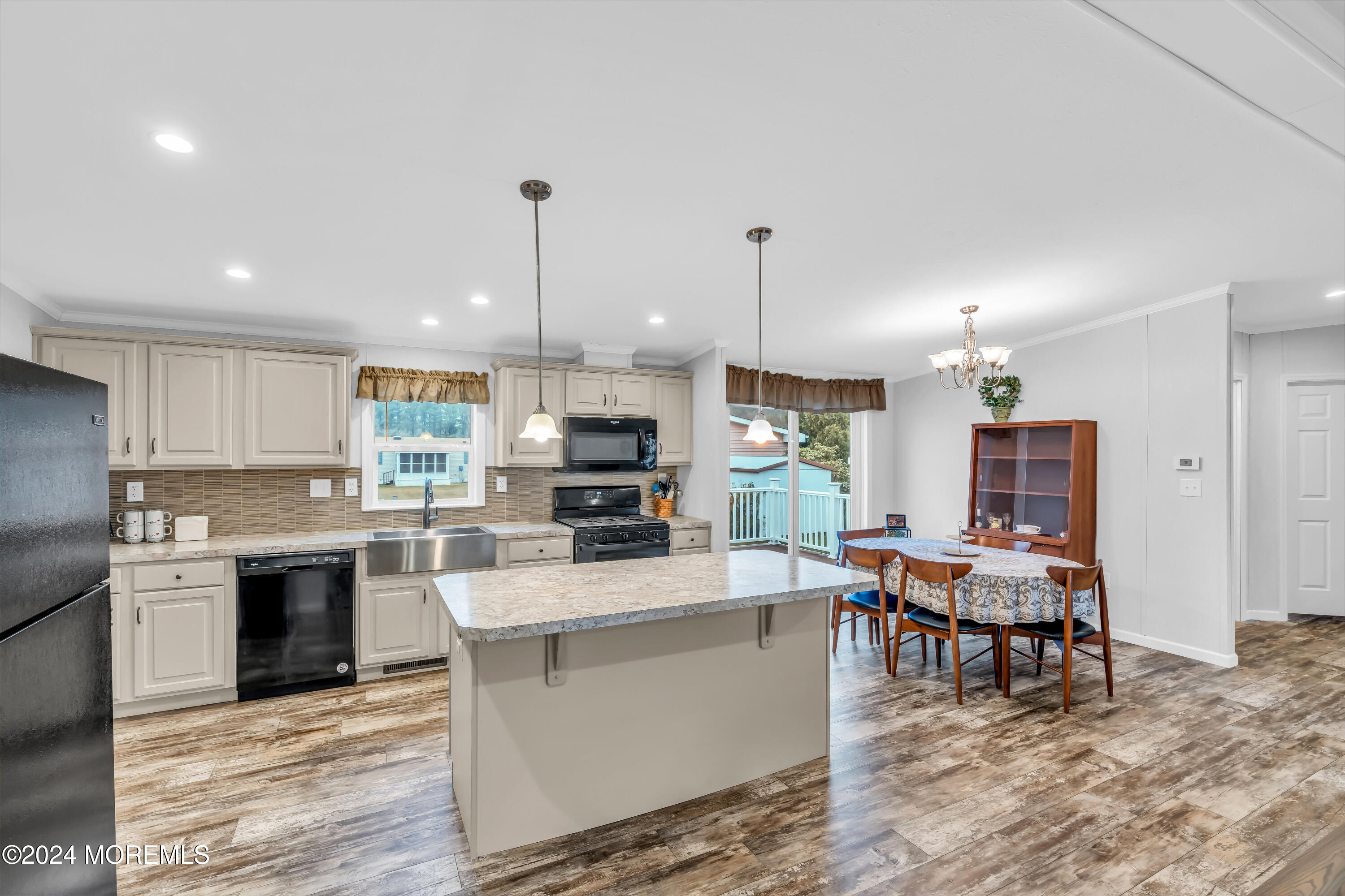 602 Jerome Place Freehold, NJ 07728 - Photo 24 of 55 a kitchen with stainless steel appliances kitchen island granite countertop a stove top oven a sink a dining table and chairs with wooden floor