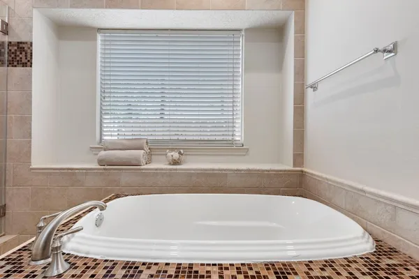 a spacious bathroom with a granite countertop tub sink shower and mirror