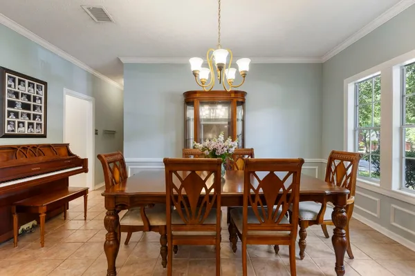 a view of a hallway with furniture and chandelier