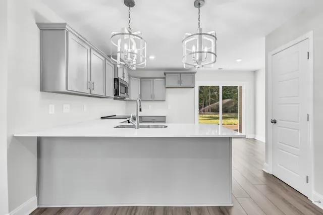 a view of a kitchen with wooden floor and windows