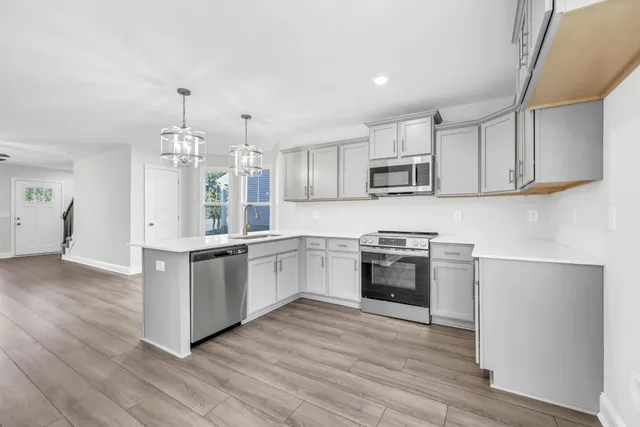 a kitchen with granite countertop white cabinets and stainless steel appliances