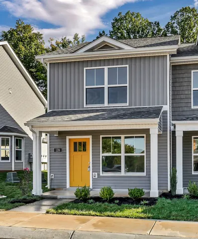 a front view of a house with a yard and potted plants