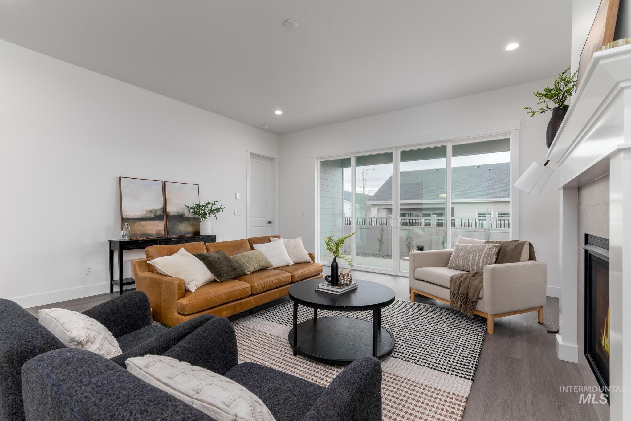 8629 West Stillmore Street Star, ID 83669 - Photo 4 of 27 Living area featuring a lit fireplace, wood finished floors, and recessed lighting