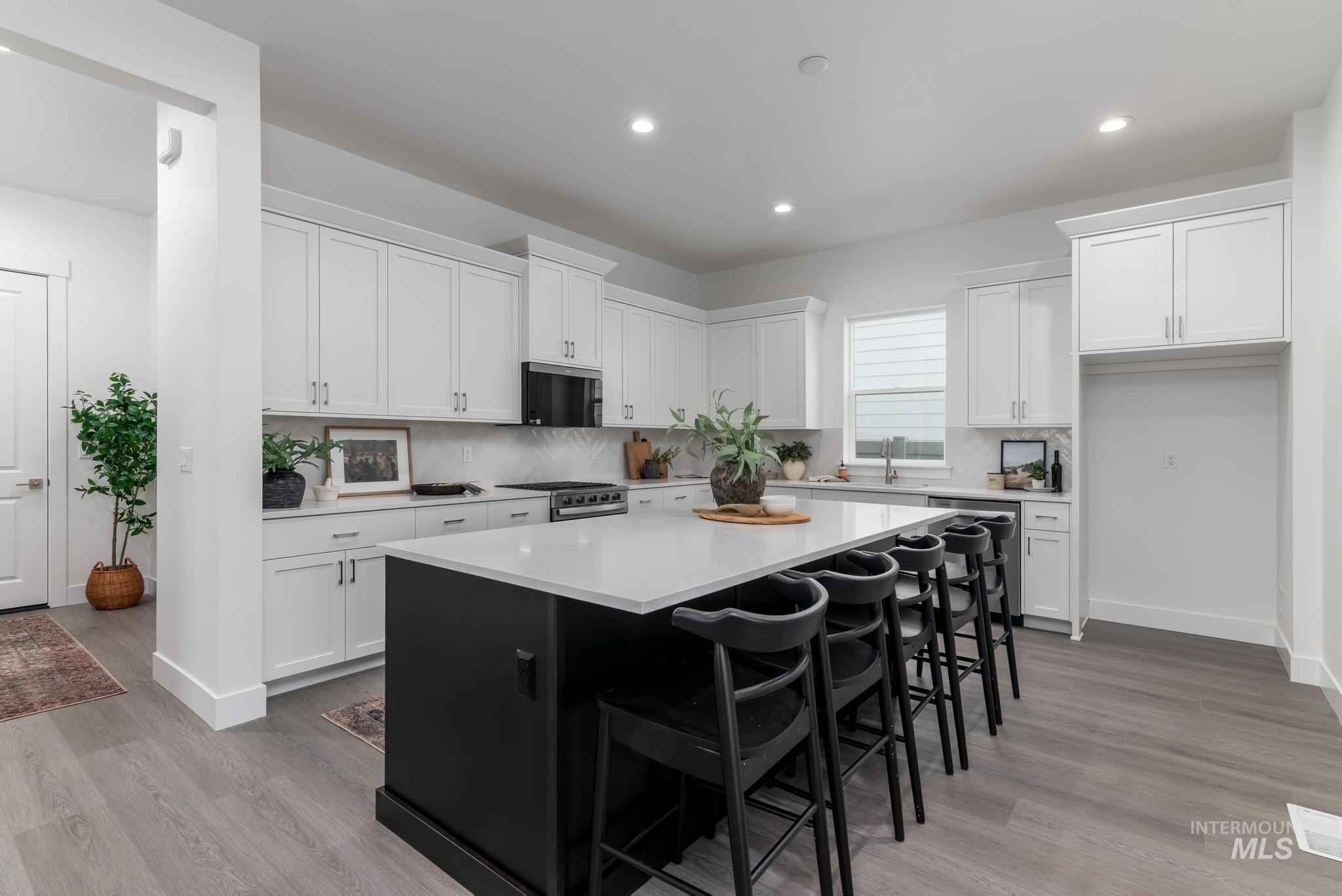 8629 West Stillmore Street Star, ID 83669 - Photo 10 of 27 Kitchen featuring dark cabinets, a breakfast bar area, a kitchen island, white cabinetry, and recessed lighting