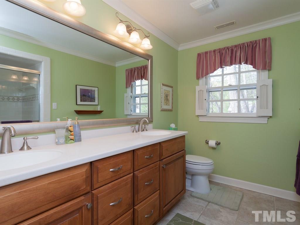 4909 Connell Drive Raleigh, NC 27612 - Photo 14 of 25 a spacious bathroom with a granite countertop toilet sink and mirror