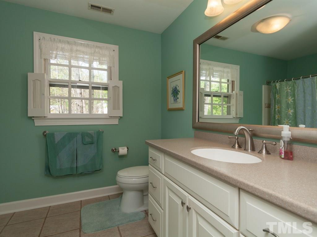 4909 Connell Drive Raleigh, NC 27612 - Photo 17 of 25 a bathroom with a granite countertop toilet sink and mirror
