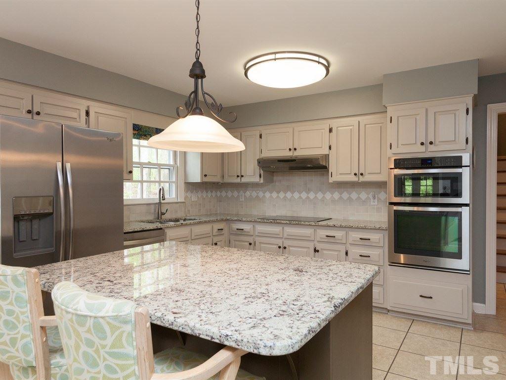 4909 Connell Drive Raleigh, NC 27612 - Photo 9 of 25 a kitchen with stainless steel appliances granite countertop a sink a microwave a refrigerator and a stove