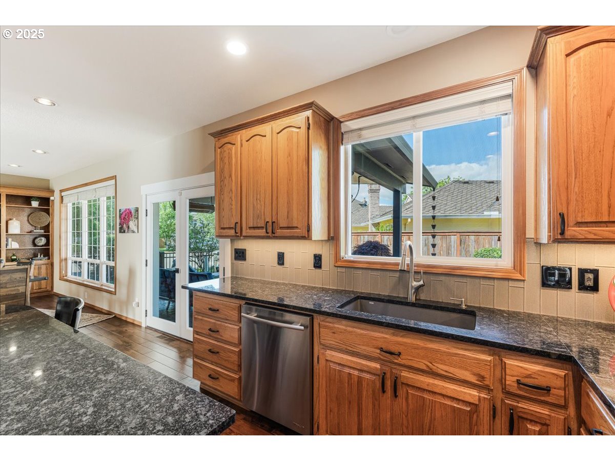 16706 Northwest Waterford Way Portland, OR 97229 - Photo 18 of 45 a kitchen with stainless steel appliances granite countertop a sink a stove and cabinets